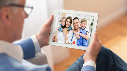 Senior Man Making Video Call With Family Online Sitting Indoor - obrazy, fototapety, plakaty