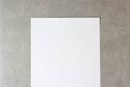 Template of white paper on light grey concrete background. Concept of new idea, business plan and strategy, development and implementation of content. Stock photo with empty space for text