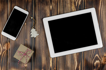 Smartphone, tablet, gift, wooden Christmas tree on a wooden background .