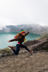 girl photographer jumping in spectacular landscape lagoon inside quilotoa volcano ecuador latin america