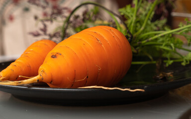 BLACK PLATE WITH FRESHLY PICKED CARROTS FROM THE URBAN GARDEN
