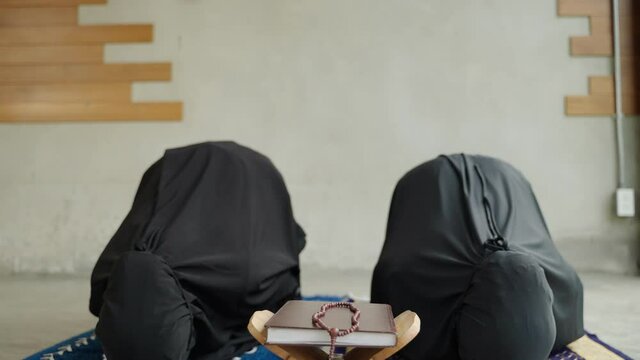 Two young Muslim women are performing prayers. Islamic religion,part 1

