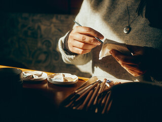 artist's hands and materials in the sun
