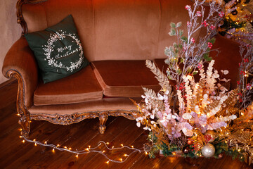 Christmas and New year decorate the interior of the room with a spacious sofa with Christmas decorations. new years eve. A room where candles and garlands are lit