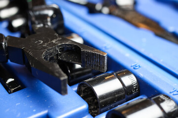 Macro close up of black isolated pliers on blue socket tool set box 