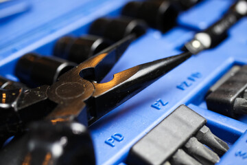 Macro close up of black isolated pliers on blue socket tool set box 