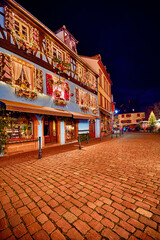 Fototapeta na wymiar beautiful decorated building facade on the square of Kaysersberg village on Christmas holidays. Alsace, France