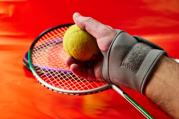 Mano de hombre con una muñequera y raqueta de tenis