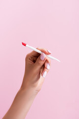 cropped view of woman holding cuticle pusher isolated on pink, stock image
