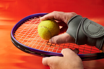Mano de hombre con una muñequera y raqueta de tenis
