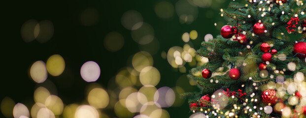 Closeup of Festively Decorated Outdoor Christmas tree with bright red balls on blurred sparkling...