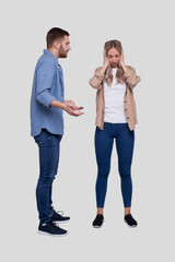 Fototapeta premium Couple Having a Fight. Man Screaming at Girl. Man is not Satisfied. Couple Standing Isolated. Girl Closing Eyers
