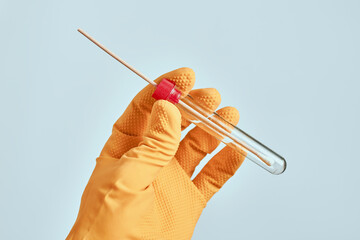 Laboratory technician holding sterile oral mouth swab in tube