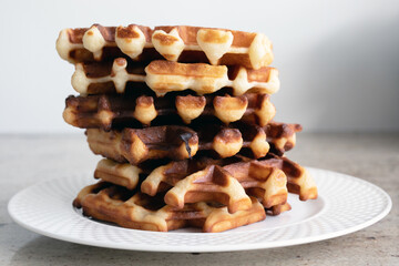 Stack of Belgian waffles on a white plate