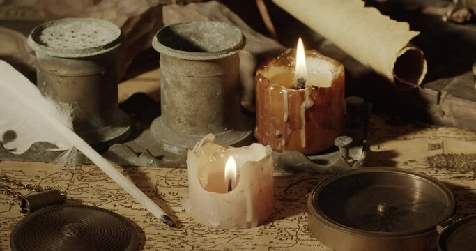 Table with antique objects and candles Ancient map of 1610.