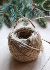 A ball of decorative threads lies on a wooden table.