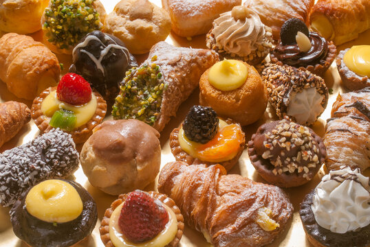 Mixed little pastries, sweet food for dessert with cream, chocolate, hazelnut, fruits, etcetera
