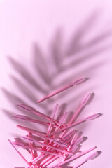 Creative concept beauty fashion photo of lashes extensions brush on pink background.