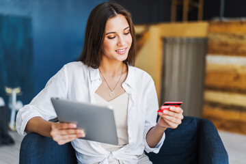 Female using bank card to pay for goods purchased online. Safe payment services for customers of worldwide retailers.