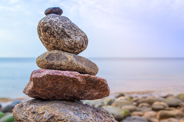 Stones pyramid on the seashore. Sunset on pebble beach. Balanced life, relax.