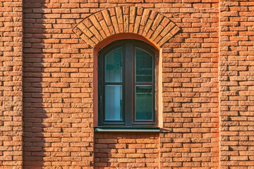 Fototapeta na wymiar Closed window in the old brick wall.
