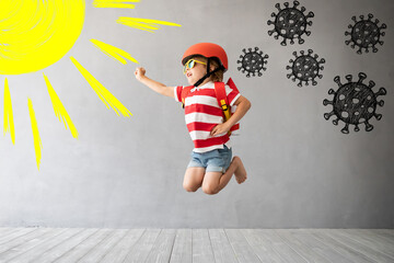 Fototapeta na wymiar Child with rocket jumping against grey concrete background