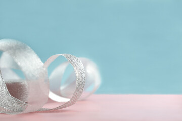  background of pastel pink and blue and silver glitter fabric ribbon.