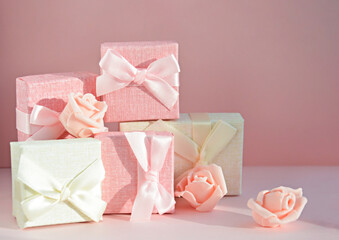 Boxes for small gifts in pastel colors and rosebuds on a light background with place for text. Advertising, poster.