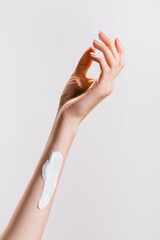 cropped view of woman with hand cream on arm isolated on grey, stock image