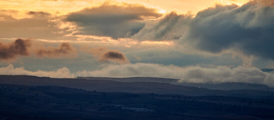 Nice autumn sunset with a cloudy sky over the silhouetted hills