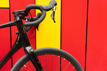 Close-up of a black metal bicycle near a bright wall. Sport equipment.