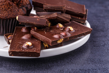 Chocolate cupcake with icing and chocolate bar in Dark lighting,Homemade delicious chocolate muffin on wooden background close-up