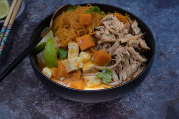 Rice noodles, sweet potato, tofu and king oyster mushroom simmered in vegan Thai red curry, copy space