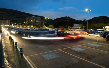 Movement of cars in a parking lot at dusk