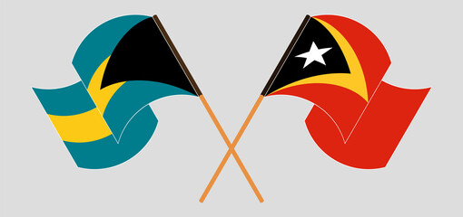 Crossed and waving flags of Bahamas and East Timor