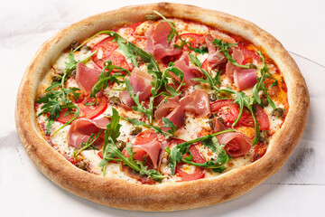 Aromatic Italian pizza with prosciutto, tomatoes, cheese, arugula, capers, tomatoes