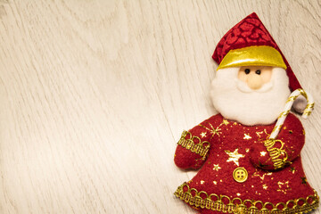 top view. toy in the shape of Santa Claus with patterns on a light gray laminate. horizontal. close-up. Christmas. New Year. Minimalistic. love. in the room. holiday symbol. copy space. vintage.