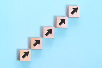 Business concept growth success process, close up wood block stacking as step stair on blue background