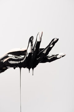 Cropped view of hand with dripping black paint isolated on white, stock image