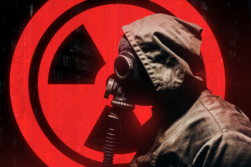 Stalker warrior in protective soviet gas mask standing on glowing red radiation sign.