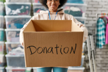 Cropped shot of smiling girl holding donation box