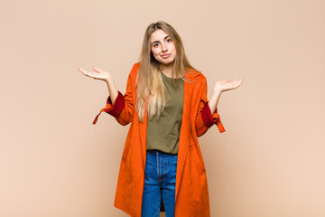 blonde woman feeling puzzled and confused, doubting, weighting or choosing different options with...