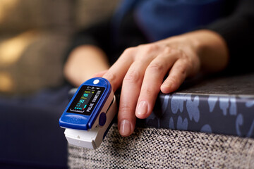 Young female hand with pulse oximeter close-up.