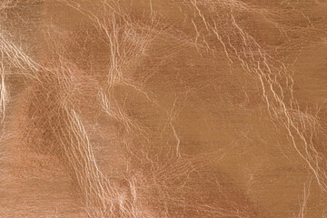 Bronze or red gold metallic color cracked foil leather texture as background pattern with copy space