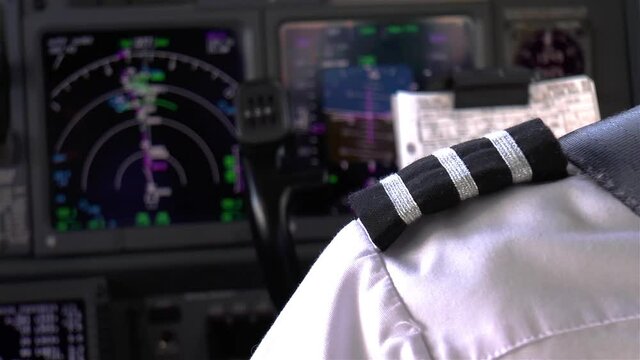 Pilot in the flight deck of a modern airliner.
A pilot monitors the flight instruments in the flight deck of a modern airliner while experiencing light turbulence.