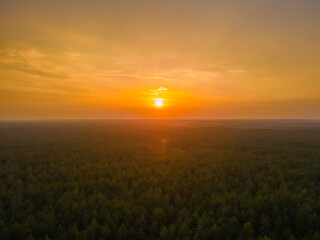 Aerial view of an orange sunset over the forest