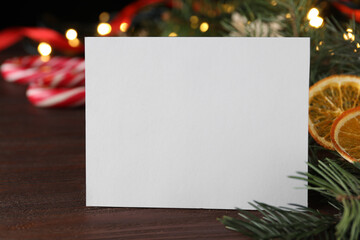 Naklejka na ściany i meble Blank greeting card near Christmas decorations on wooden table, closeup. Space for text