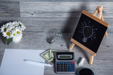 light bulb drawing on blackboard and business desk