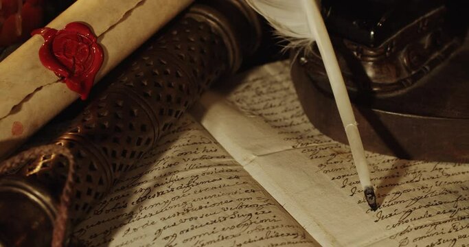 Old manuscript and feather pen illuminated by candles