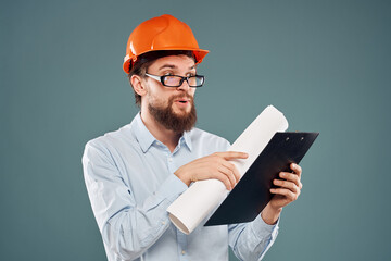 man in orange hard hat blueprints in hands construction industry blue background